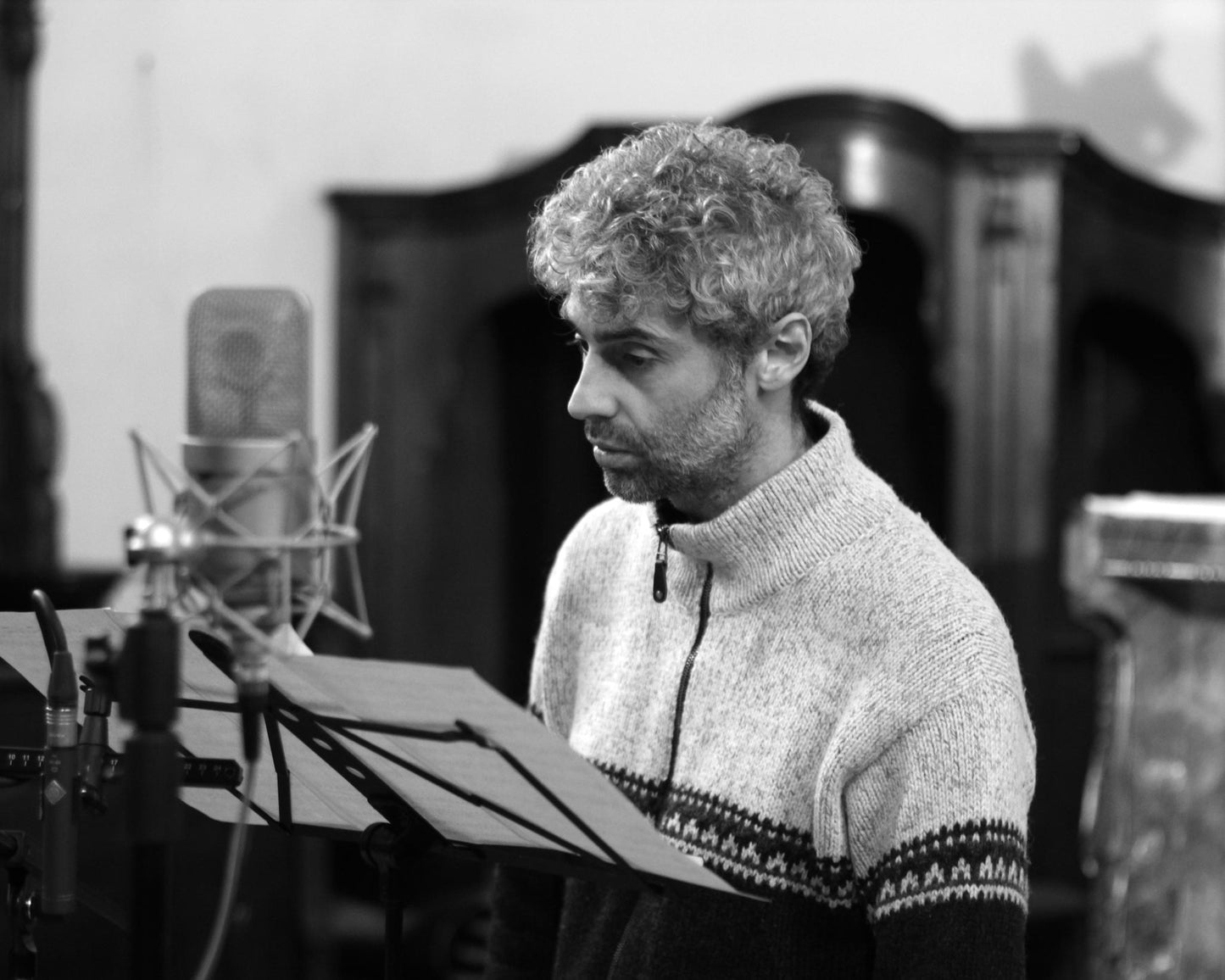 Enea Sorini singing in front of a microphone during the recording sessions of the album "Quando cala la notte".