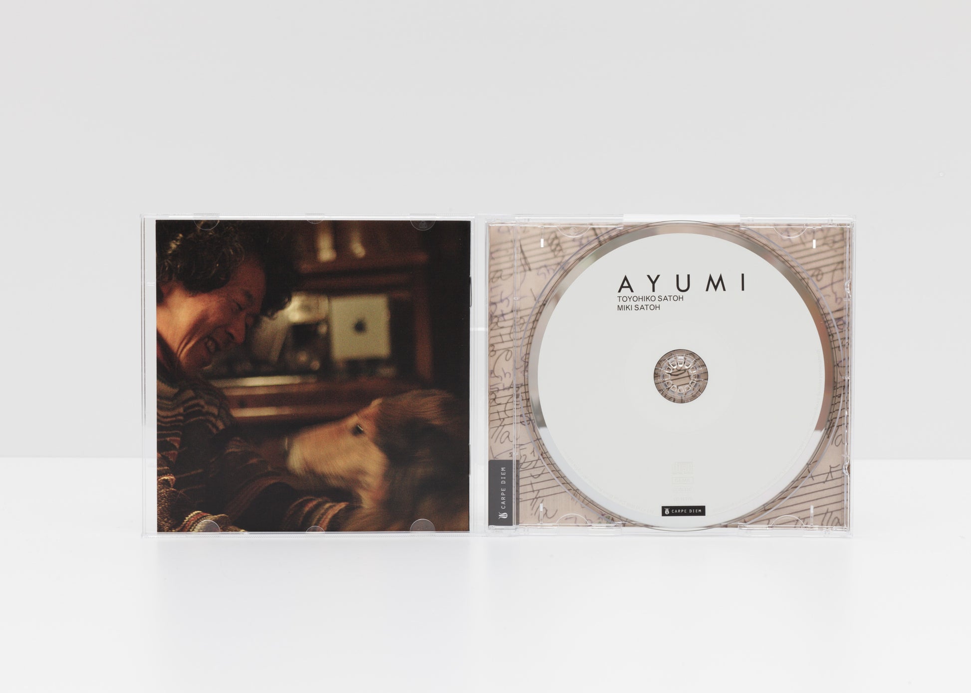 Jewelcase detail of the album "Ayumi" by Toyohiko Satoh and Miki Satoh, showing a portrait of Toyohiko Satoh and the CD. 