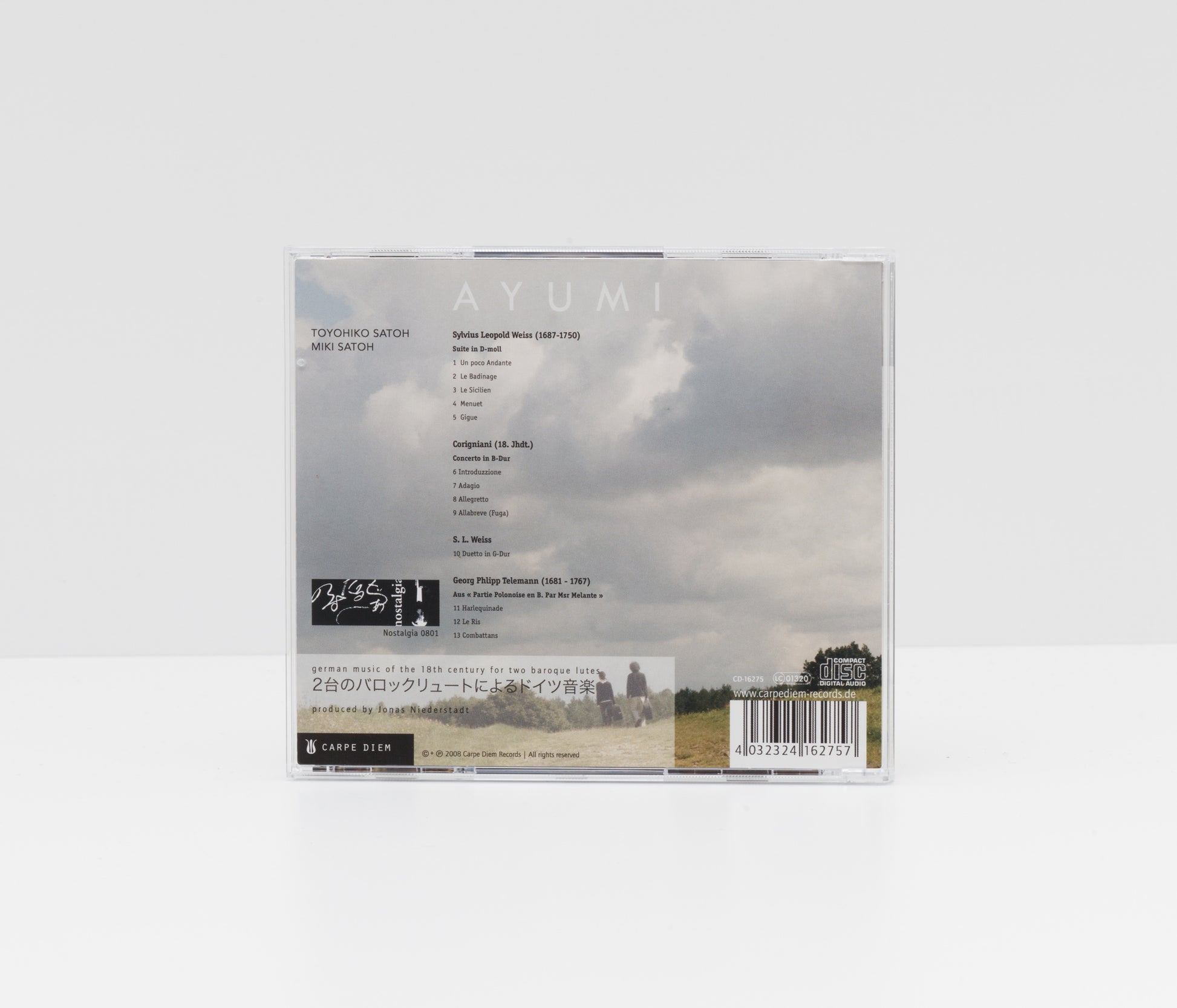 Jewelcase back cover of the album "Ayumi" by Toyohiko Satoh and Miki Satoh, showing a picture of the two artists walking in the fields. 