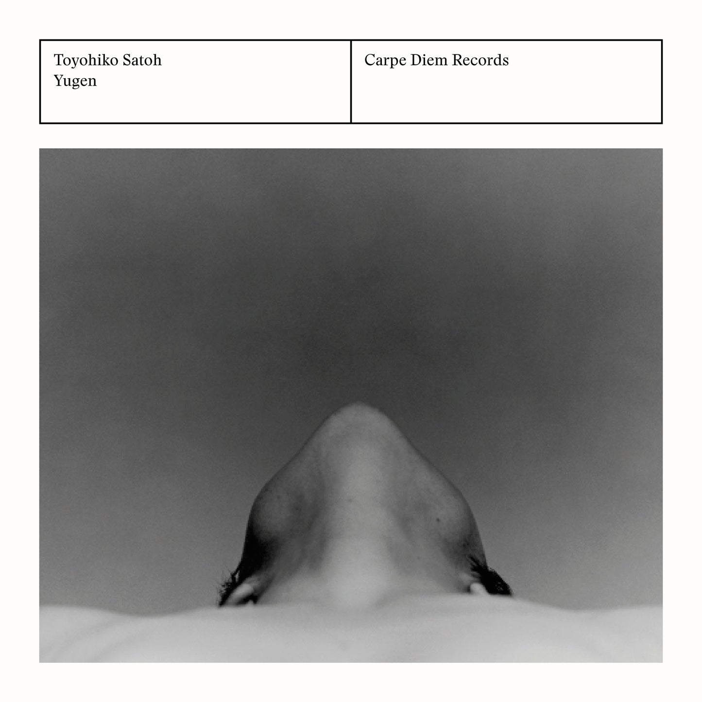 Back cover of the album "Yugen" by Toyohiko Satoh, Walter van Hauwe and Chiyomi Yamada featuring a monochrome portrait of a person from below.