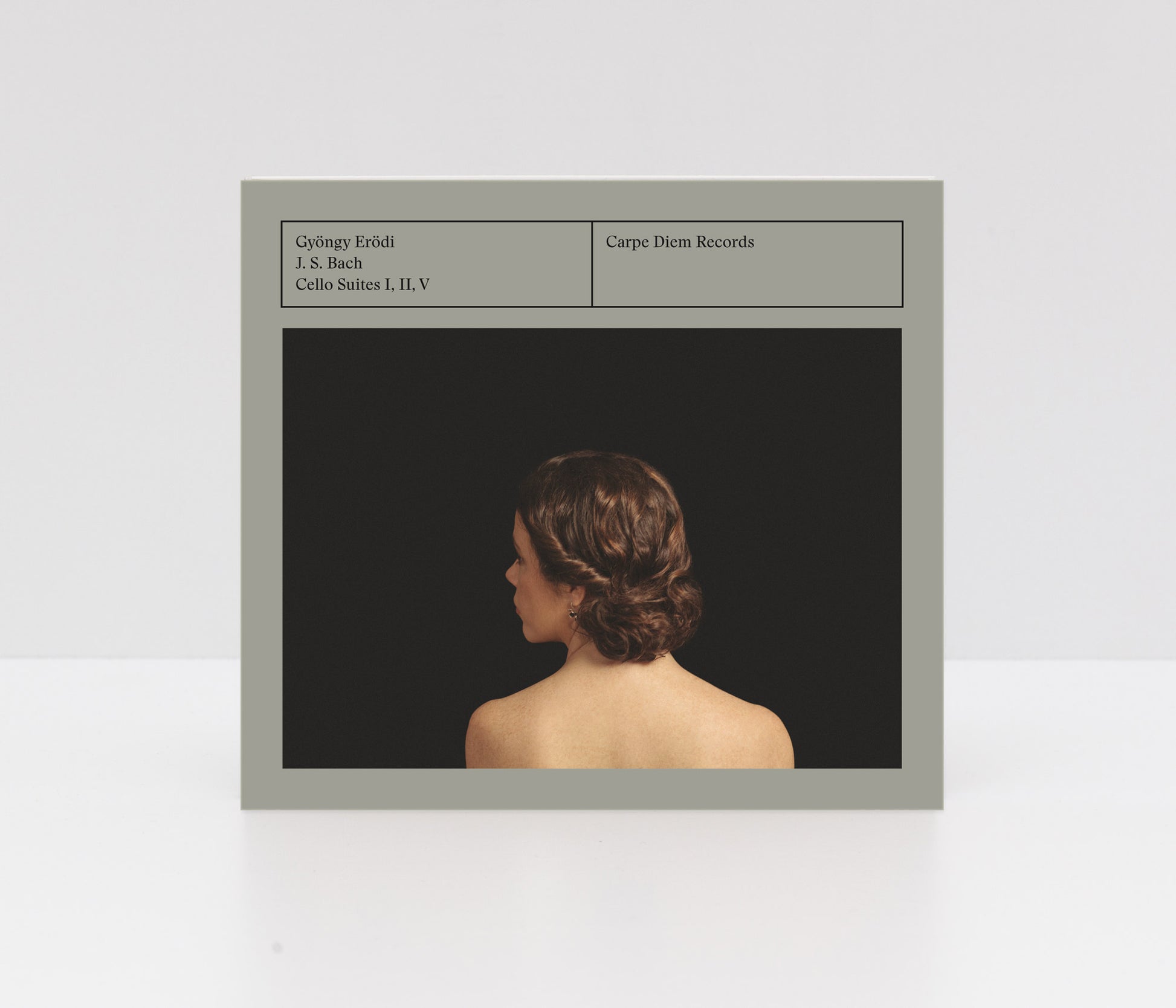 Digipack cover of Gyöngy Erödi's album "J. S. Bach Cello Suites I, II, V" showing a back porttrait of the artist in front of a black backdrop. 