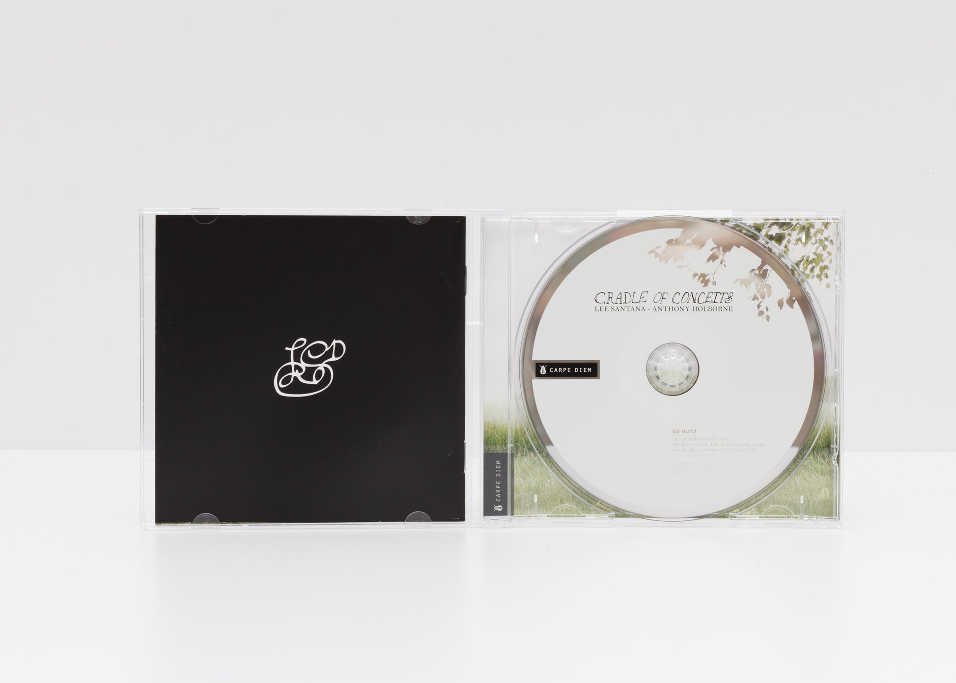 Jewelcase detail of "Cradle of Conceits" by Lee Santana, showing the artist's signature and the CD.