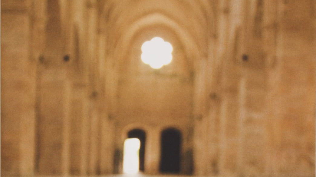 Blurred image of a stone archway with light source
