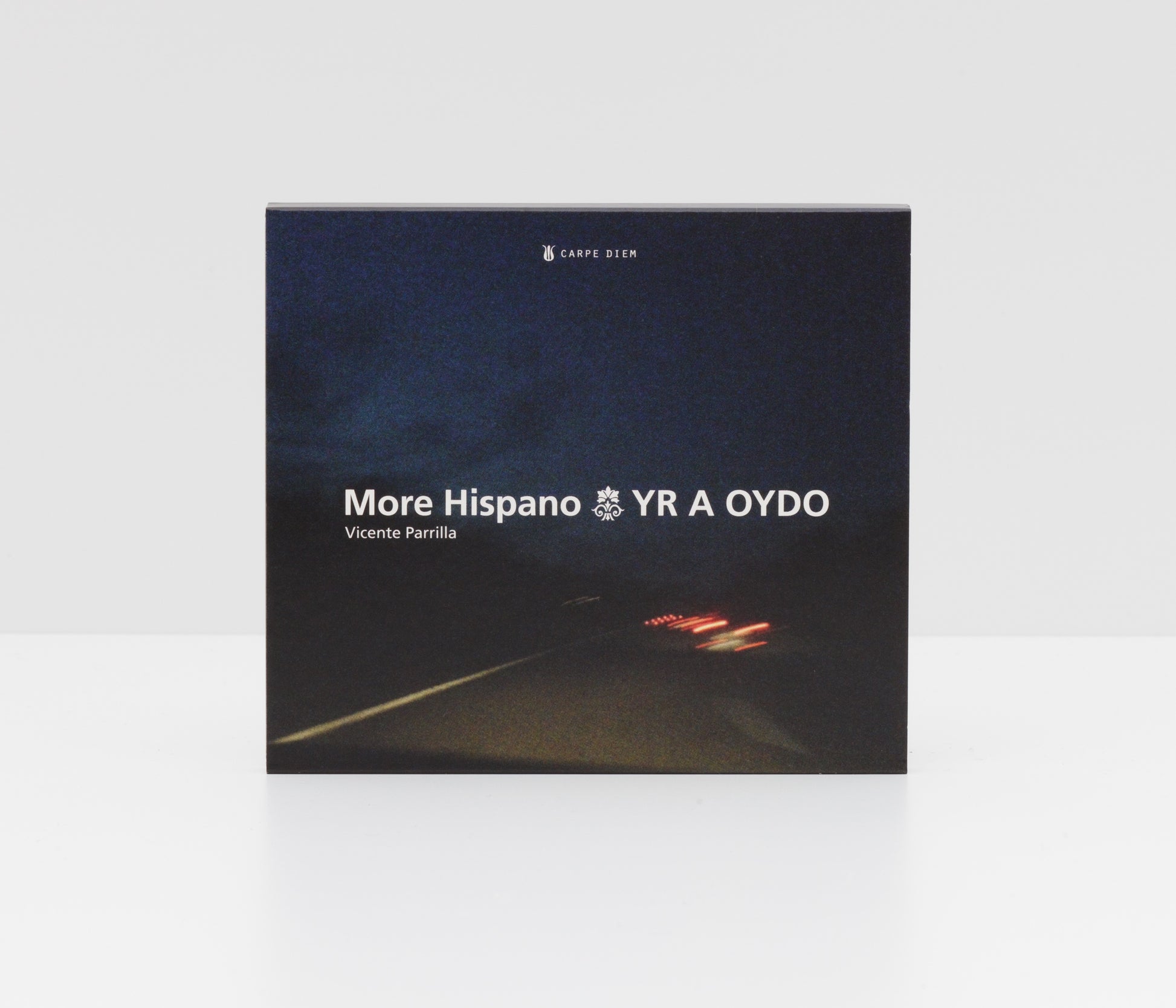 Jewelcase album cover of "Yr a oydo" by More Hispano (Vicente Parrilla) & Raquel Andueza, showing gloomy car lights on a highway at night